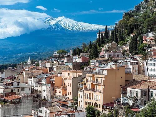 a view of a city with a snow covered mountain at Holiday Home Gionny & Mary in Taormina