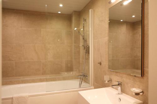 a bathroom with a shower and a tub and a sink at MyApartments in Tallinn