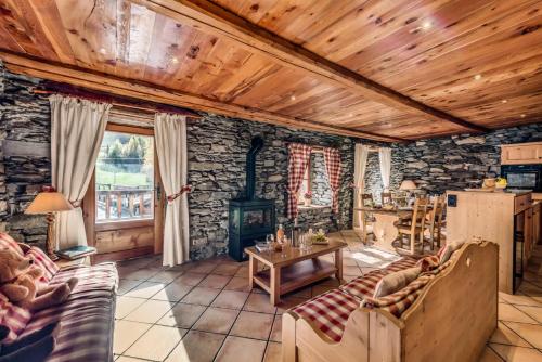 a living room with a stone wall at Chalet Les Champs Du Pont - Chalets pour 15 Personnes 591 in Tignes