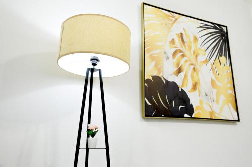 a lamp with a flower in a vase next to a wall at Cozy apartment New Cairo in New cairo