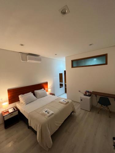 a bedroom with a large bed and a desk at Bistu Hotel - Vila Nova Conceição in Sao Paulo