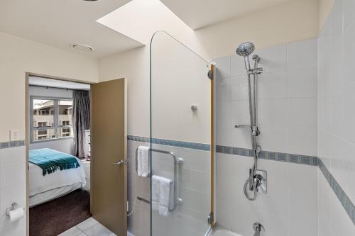 a bathroom with a shower and a bedroom at Apartment 407 - Mount Maunganui Apartment in Mount Maunganui
