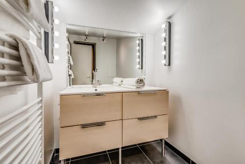ein Bad mit einem Waschbecken und einem Spiegel in der Unterkunft Résidence Hameaux De Toviere - 3 Pièces pour 6 Personnes 711 in Tignes