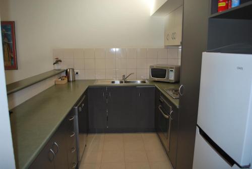 a small kitchen with a sink and a microwave at 24 Gillies St Apartment in Warrnambool