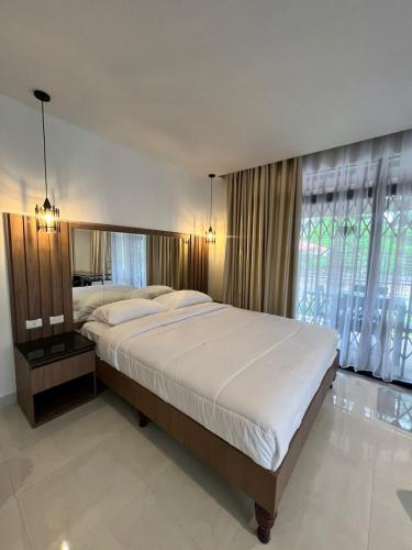a bedroom with a large bed and a large window at NOVAPARK FERROVIARIA in Guayaquil