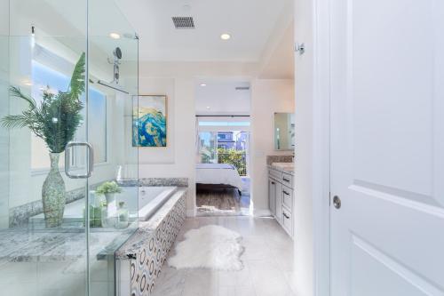 a bathroom with a glass shower and a sink at New Luxurious Beach Home in Huntington Beach