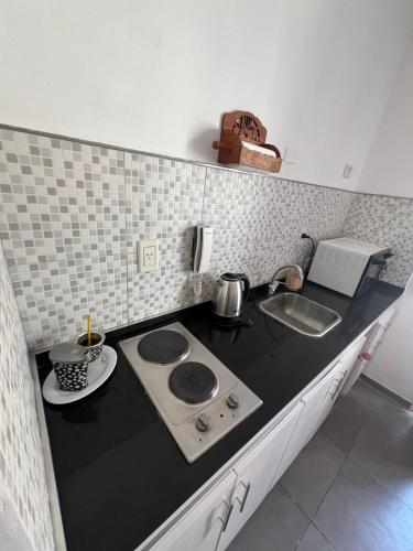 a kitchen counter with a stove and a sink at Departamento Mis Nonos 3 in Mendoza