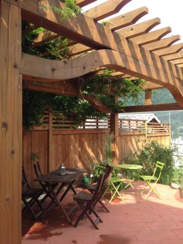 a patio with a table and chairs under a wooden pergola at Mistiso's Place Vacation Rentals in Nelson