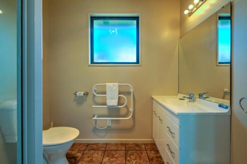 a bathroom with a sink and a toilet and a mirror at 20 Rippingale Road in Hanmer Springs