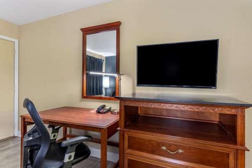 a room with a desk and a television and a chair at ECONO LODGE in Erlanger
