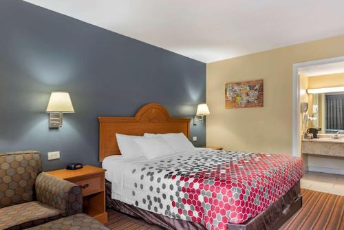 a hotel room with a bed and a chair at ECONO LODGE in Erlanger