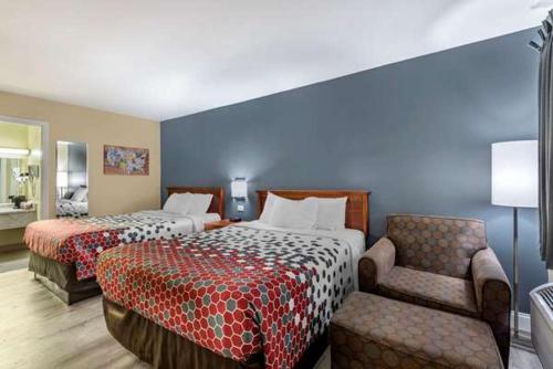 a hotel room with two beds and a chair at ECONO LODGE in Erlanger