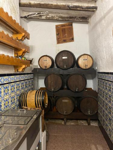 a bunch of wine barrels stacked on a wall at Pink Lemon House in Elche