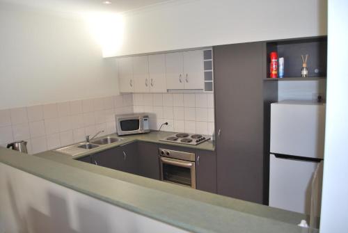 a kitchen with a white refrigerator and a microwave at 24 Gillies St Apartment in Warrnambool