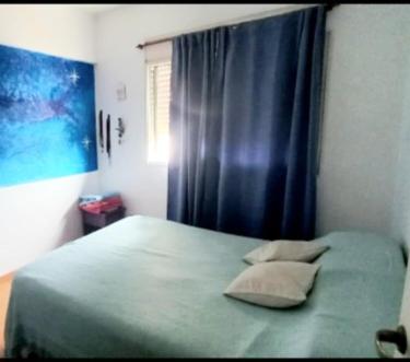 a bedroom with a bed with a blue curtain at Torre 5 in Junín
