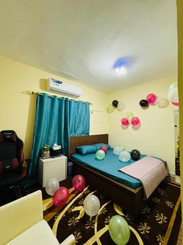 Dream Studio Room/Abu-Dhabi في أبوظبي: غرفة نوم بها بالونات على الحائط وسرير