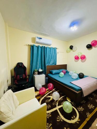 um quarto com uma cama e balões no chão em Dream Studio Room/Abu-Dhabi em Abu Dhabi