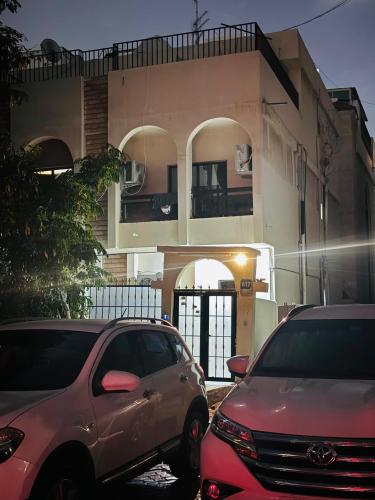 Dream Studio Room/Abu-Dhabi في أبوظبي: سيارتين متوقفتين امام مبنى