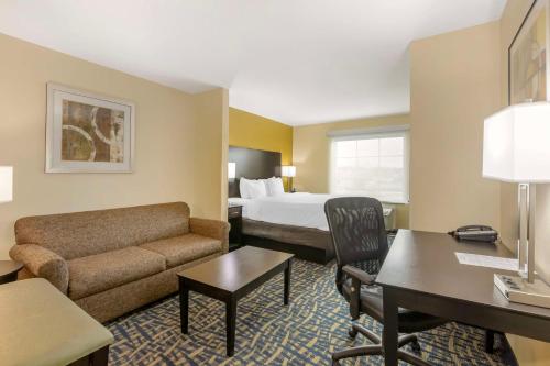 Best Western Plus Brunswick Inn & Suites في برونزويك: غرفه فندقيه بسرير واريكه