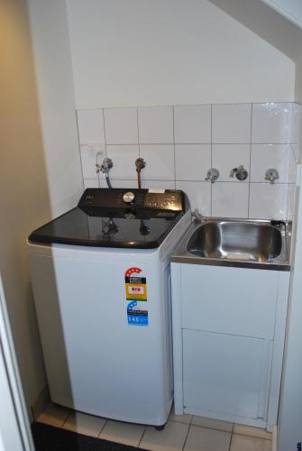 a small kitchen with a sink next to a sink at 24 Gillies St Apartment in Warrnambool