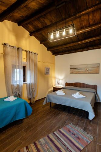 two beds in a room with wooden ceilings at Fattoria F.lli Marsolo in Chiusa Sclafani