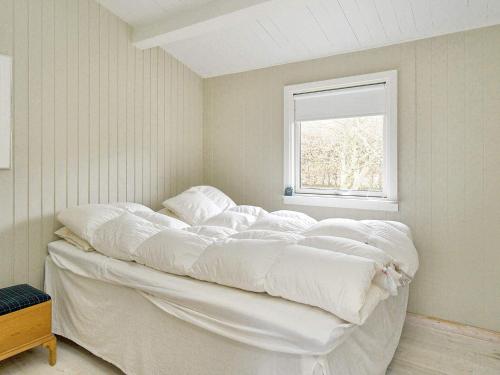 duże białe łóżko w pokoju z oknem w obiekcie Holiday home Vejby XXVII w mieście Vejby