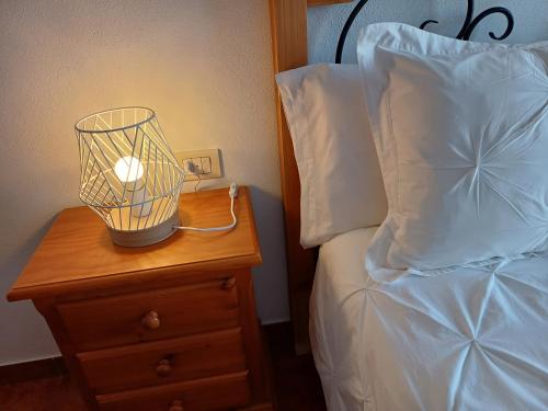 a lamp on a night stand next to a bed at Vv - Casa Clary -Finca Medina in Alojera