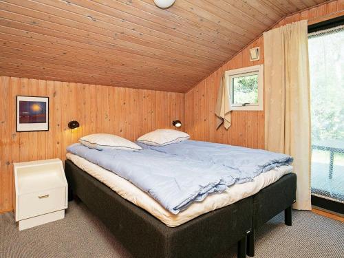 a bedroom with a large bed in a wooden room at 6 person holiday home in Ålbæk in Ålbæk
