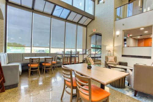 a restaurant with tables and chairs and large windows at Drury Inn and Suites St Louis Collinsville in Collinsville