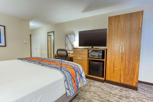 a hotel room with a bed and a flat screen tv at Drury Inn and Suites St Louis Collinsville in Collinsville