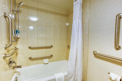 a bathroom with a tub and a shower with a toilet at Drury Inn and Suites St Louis Collinsville in Collinsville