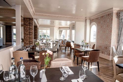 a restaurant with tables and chairs in a room at Thames Riviera Hotel, Sure Hotel Collection by Best Western in Maidenhead