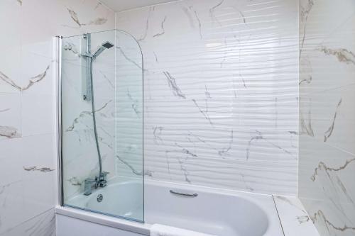 La salle de bains blanche est pourvue d'une douche et d'un lavabo. dans l'établissement Thames Riviera Hotel, Sure Hotel Collection by Best Western, à Maidenhead