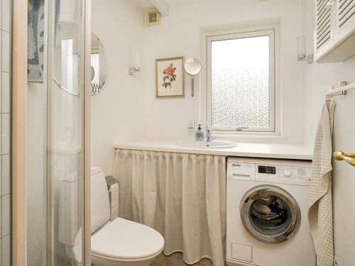 y baño con aseo, lavabo y lavadora. en Holiday home Frederiksværk XVI, en Frederiksværk