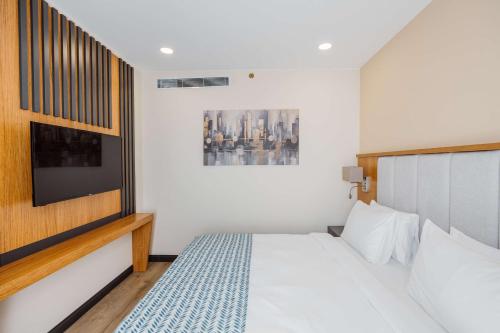 a small bedroom with a bed and a tv at Best Western Plus Batumi in Batumi