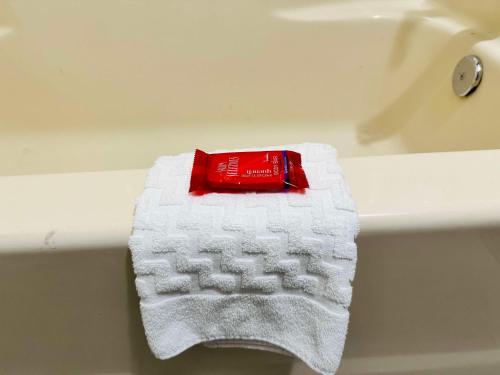 a red and white towel sitting on a bath tub at SureStay Plus by Best Western St. James Donaldsonville in Donaldsonville