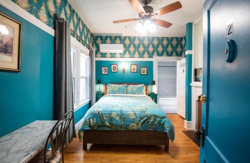 a blue bedroom with a bed and a ceiling fan at Prince Street Suites in Charlottetown
