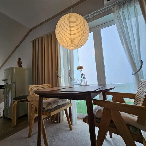 a dining room with a table and a large window at Soban Stay in Busan