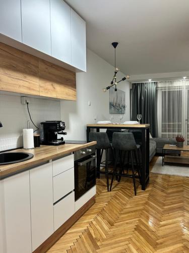 a kitchen with white cabinets and a table with chairs at House Inn in Pirot