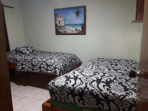 Cette chambre comprend 2 lits et une photo murale. dans l'établissement APARTA-HOTEL YINNAM ARRIETA, à San Andrés