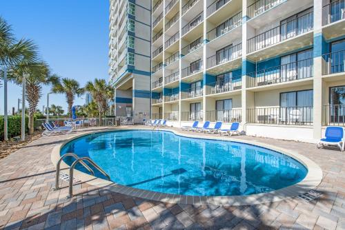 a swimming pool in front of a apartment building at Oceanview Modern 1BR, king bed at Carolinian Resort" in Myrtle Beach
