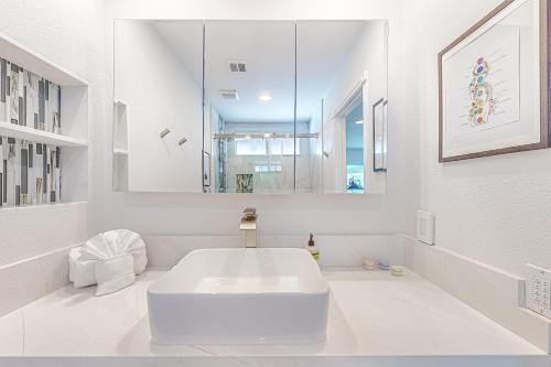 uma casa de banho branca com um lavatório e um espelho em Tamarisk Mountain View #5627 em Palm Springs