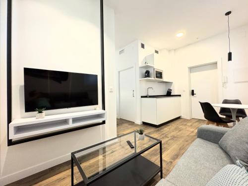 a living room with a large flat screen tv on a wall at Apartamentos Identia Sport by gaiarooms in León