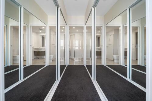 La grande salle de bains est pourvue de miroirs et de lavabos. dans l'établissement Glorious Central Canberra 1-Bed with Pool & Sauna, à Canberra