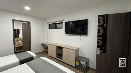 um quarto de hotel com duas camas e uma televisão de ecrã plano em M A Hotel em Popayán
