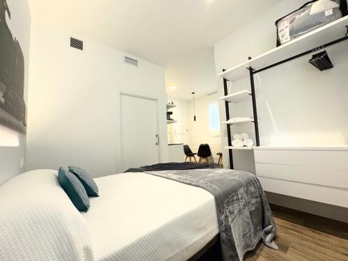 a white bedroom with a bed and a mirror at Apartamentos Identia Sport by gaiarooms in León