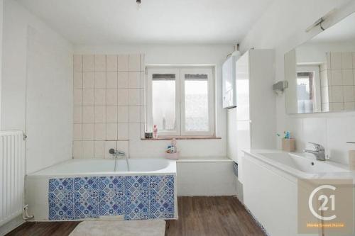 Baño blanco con bañera y lavamanos en appartement charmant à Zaventem en Zaventem