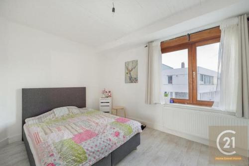 a white bedroom with a bed and a window at appartement charmant à Zaventem in Zaventem