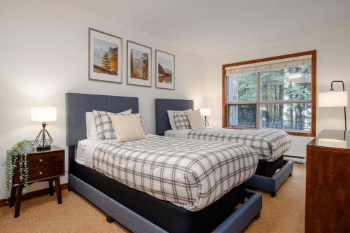 a bedroom with two beds and a window at Ski In Ski Out Apartment w Pool and Hot Tub by Harmony Whistler in Whistler