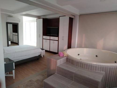 a large bathroom with a tub and a bed at Finca Hotel los Nogales in Quimbaya